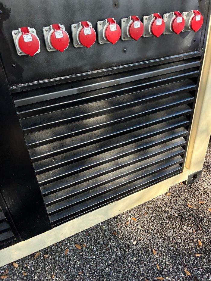 Close-up of red three-phase reefer receptacles above black
                  ventilation louvres.