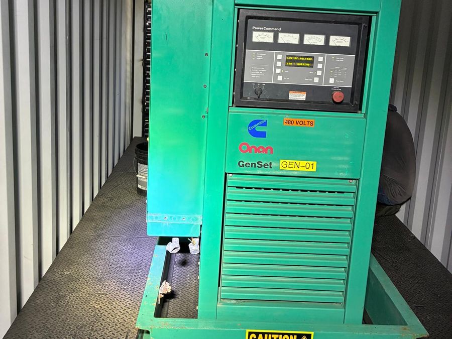 Green Cummins Onan genset inside its container, with the
                    PowerCommand control panel on the front of the enclosure.